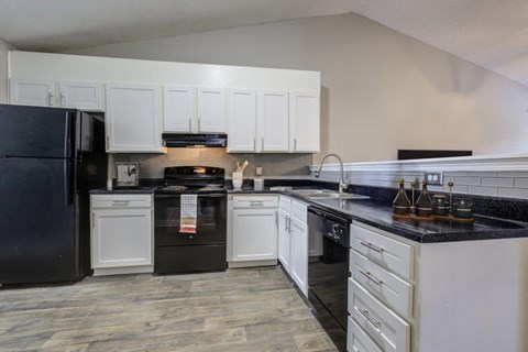 a kitchen with white cabinets and black appliances