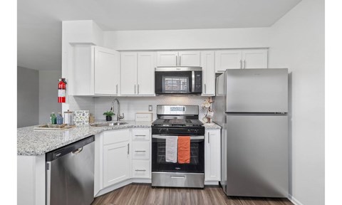 A modern kitchen with stainless steel appliances and white cabinets.