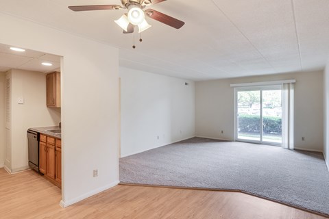 A room with a ceiling fan and carpeting.