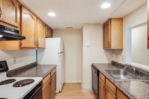 A kitchen with wooden cabinets and a white refrigerator.