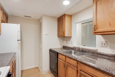 A kitchen with wooden cabinets and a granite countertop.