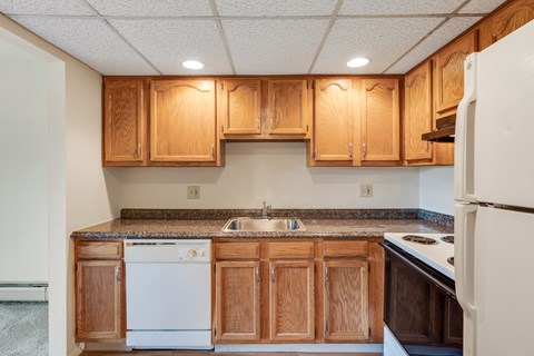 A kitchen with wooden cabinets and a white refrigerator.