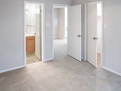 A white room with three doors and one open.