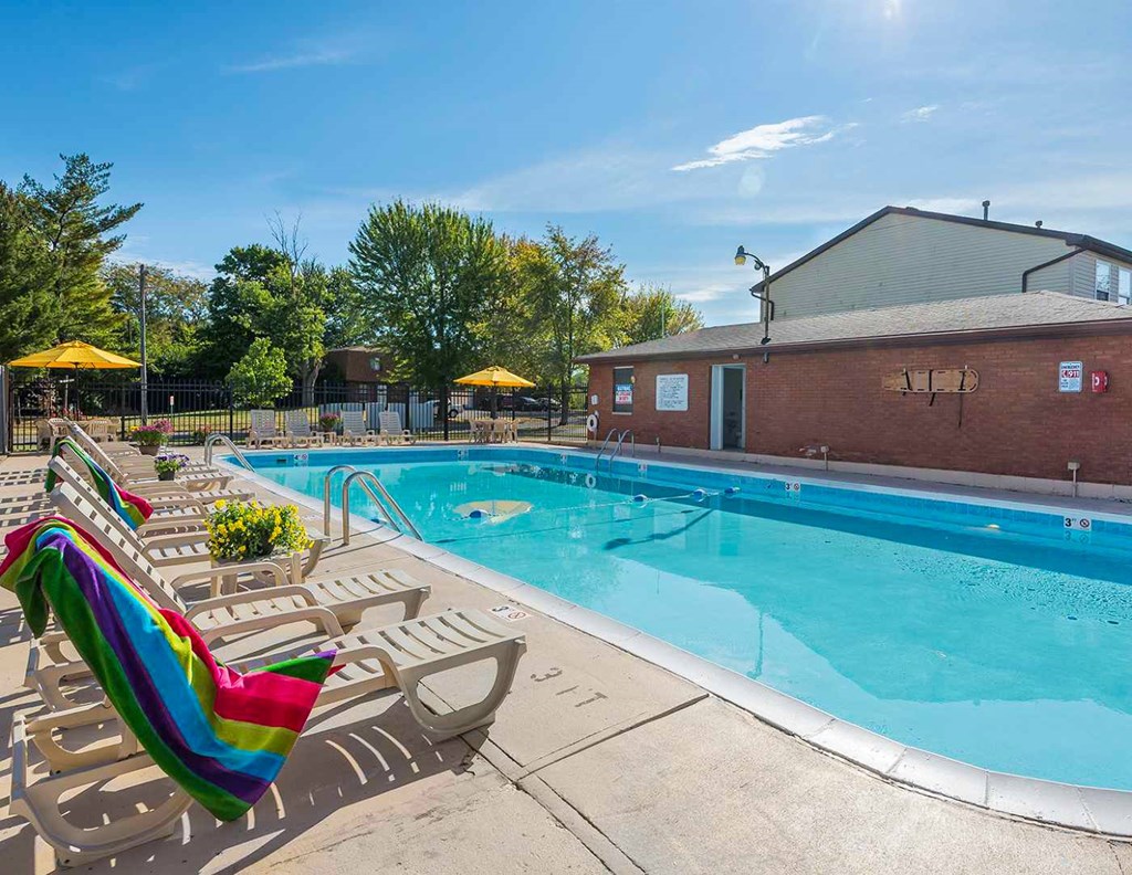 A pool with a rainbow flag on a sunny day.