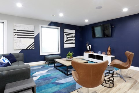 A living room with a grey couch, a brown chair, and a white table.