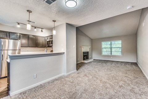 A kitchen with a refrigerator, cabinets, and a countertop is shown.