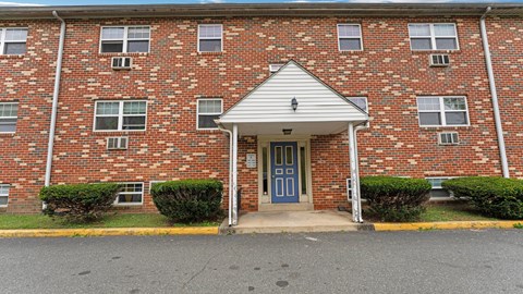 A brick building with a blue door and windows.
