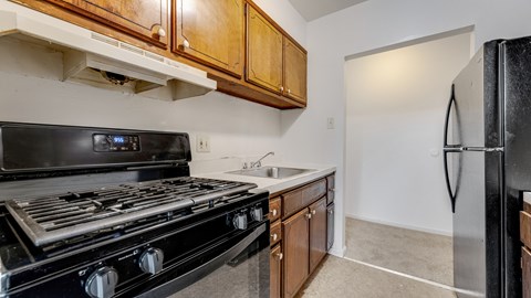 A black stove top oven in a kitchen with wooden cabinets.