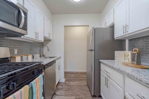 A kitchen with white cabinets and a black stove top.