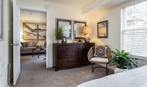 a bedroom with a dresser and a chair