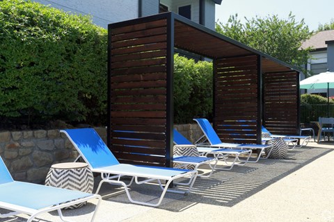 A row of blue and white lounge chairs are arranged on a patio.