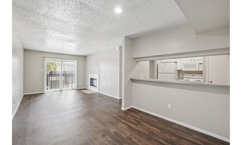 A spacious room with wooden floors and a large window.
