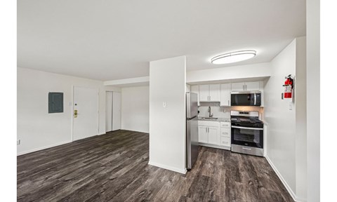 A kitchen with white cabinets and a stainless steel refrigerator.