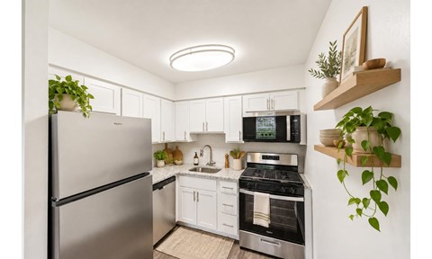 A modern kitchen with stainless steel appliances and white cabinets.