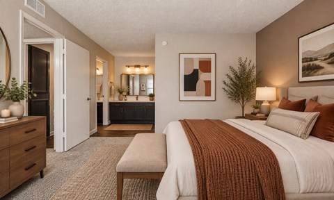 A bedroom with a large bed and a bench in front of it.