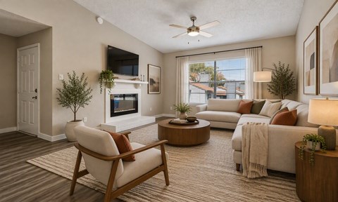 A living room with a white couch, a chair, and a television on the wall.