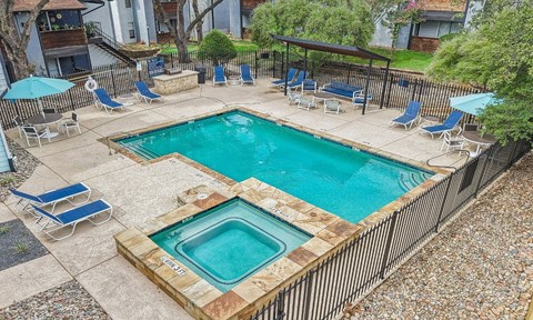 A small pool with a hot tub in the middle of it.