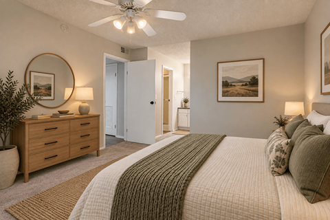 A bedroom with a large bed and a ceiling fan.