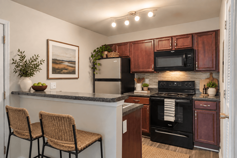 A kitchen with brown cabinets and a black oven.