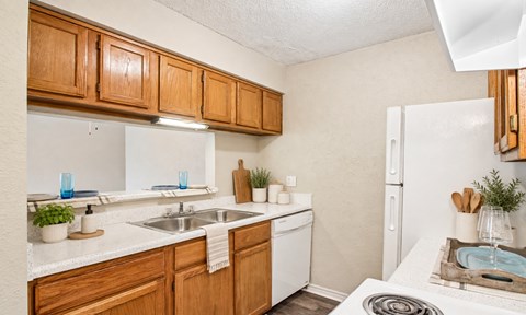 A kitchen with wooden cabinets and white appliances.