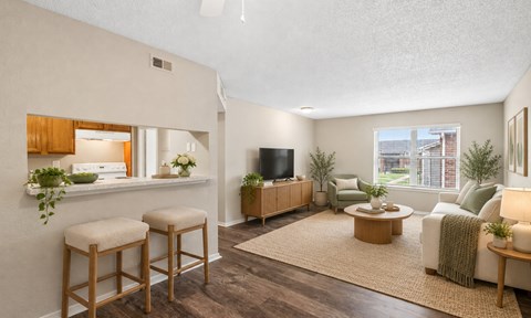 A living room with a flat screen TV and a bar area.