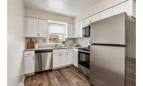 A kitchen with white cabinets and stainless steel appliances.