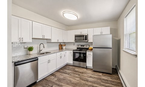 A kitchen with white cabinets and stainless steel appliances.