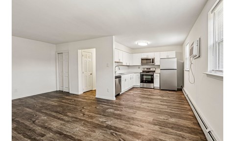 A kitchen with white cabinets and a microwave above the oven.