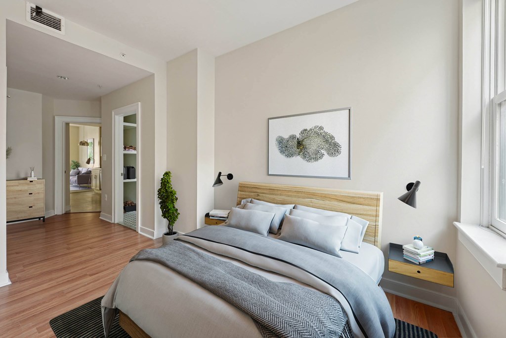 A bedroom with a large bed and a painting on the wall.