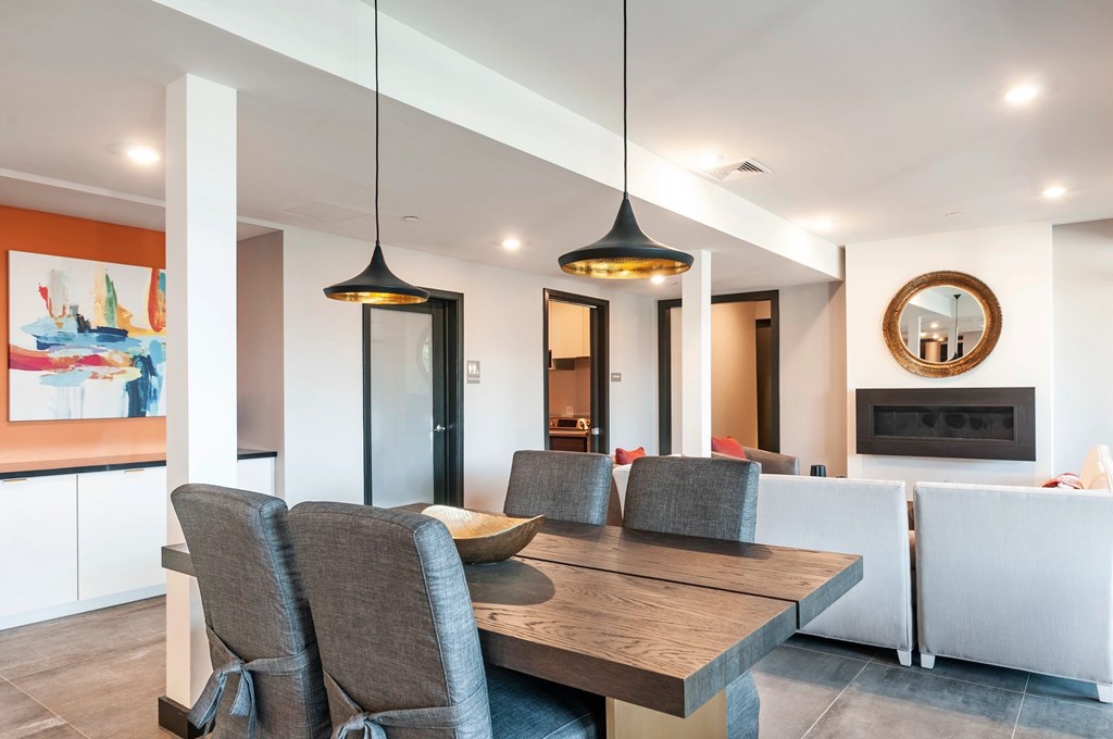 A modern dining room with a wooden table and grey chairs.