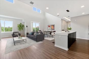 A living room with a grey couch, a white coffee table, and a large window.