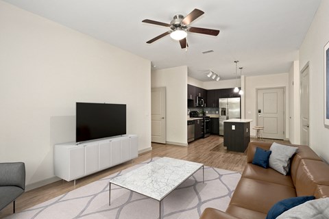 A living room with a brown leather couch and a white coffee table.