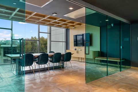 A conference room with a glass table and chairs.