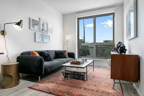 A living room with a black couch and a coffee table.