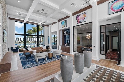 A spacious living room with a large window, a sofa set, and a rug.