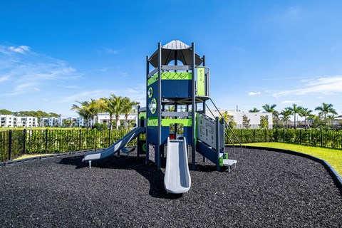 A playground with a blue slide and a white slide.