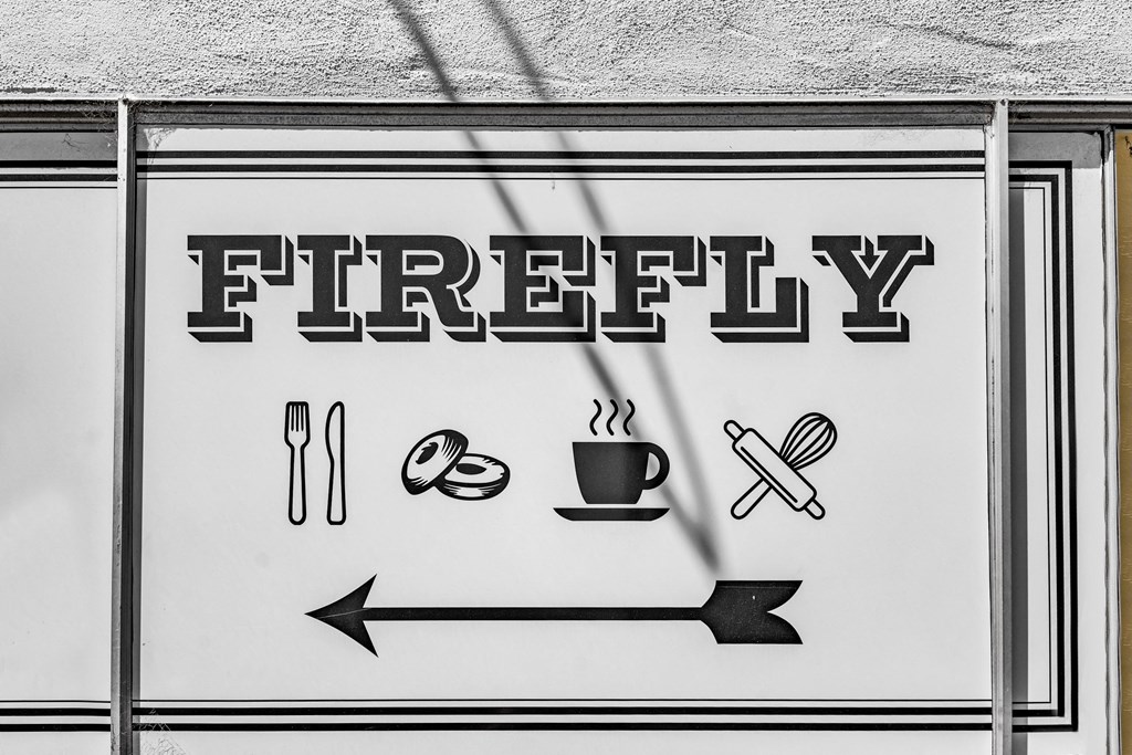 a street sign that reads firey with a arrow pointing to a cup of coffee