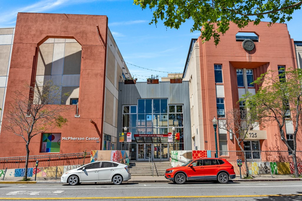 a street view of a building with two cars parked in front of it