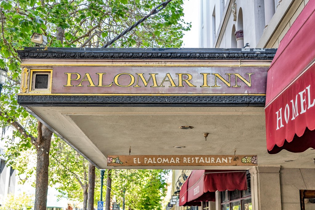 a sign for the palomar inn on the side of a building