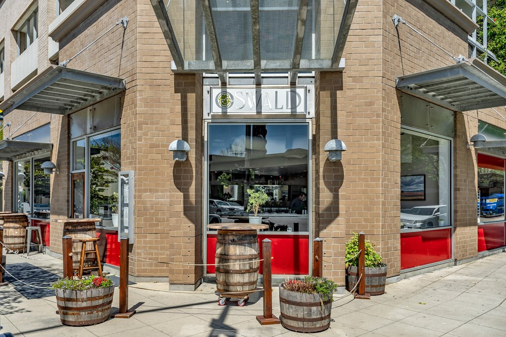the front of a restaurant with barrels in front of it