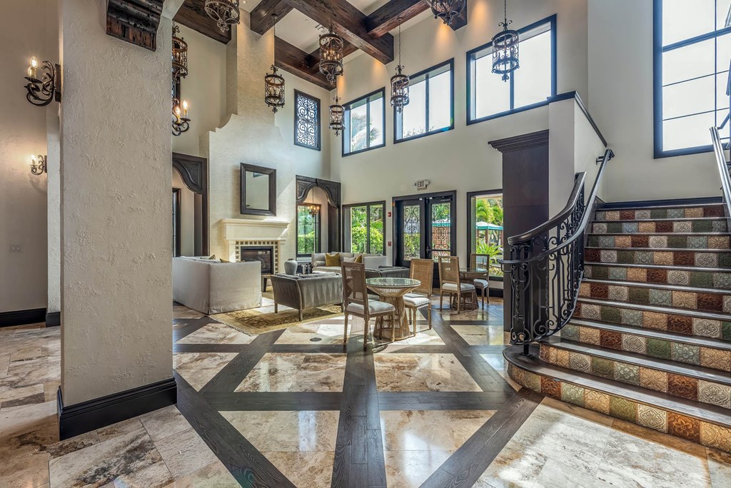 A large foyer with a staircase and a marble floor.