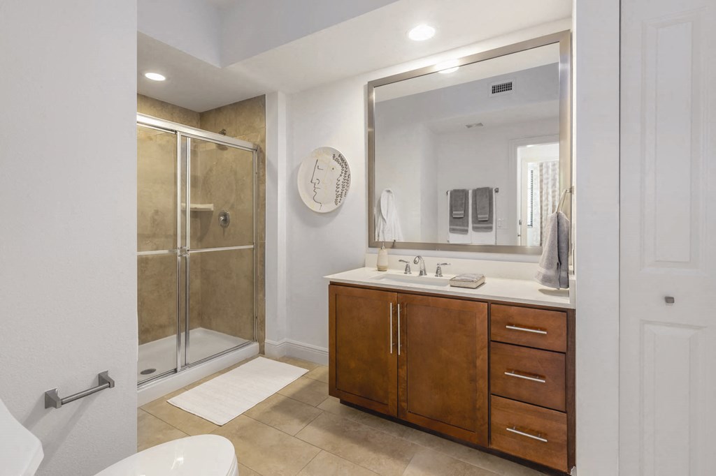 A bathroom with a toilet, sink, and mirror.