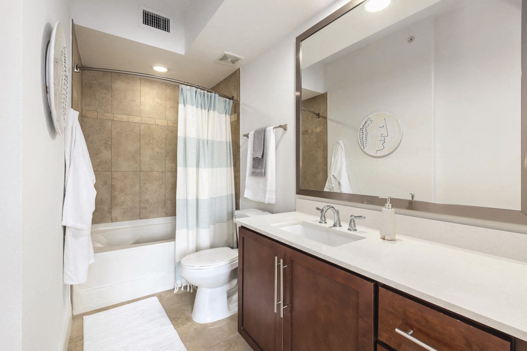 A bathroom with a toilet, sink, and shower.