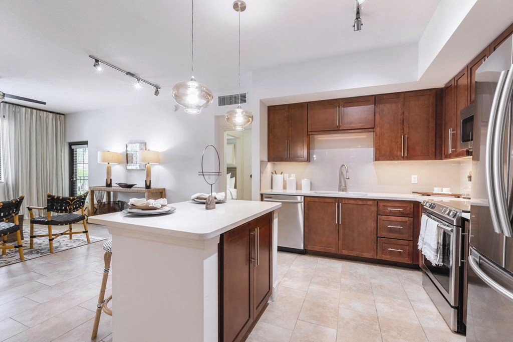 A kitchen with a white island and wooden cabinets.