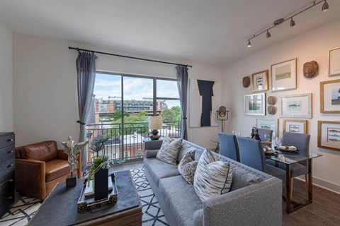 A living room with a grey couch and a coffee table in front of a large window.