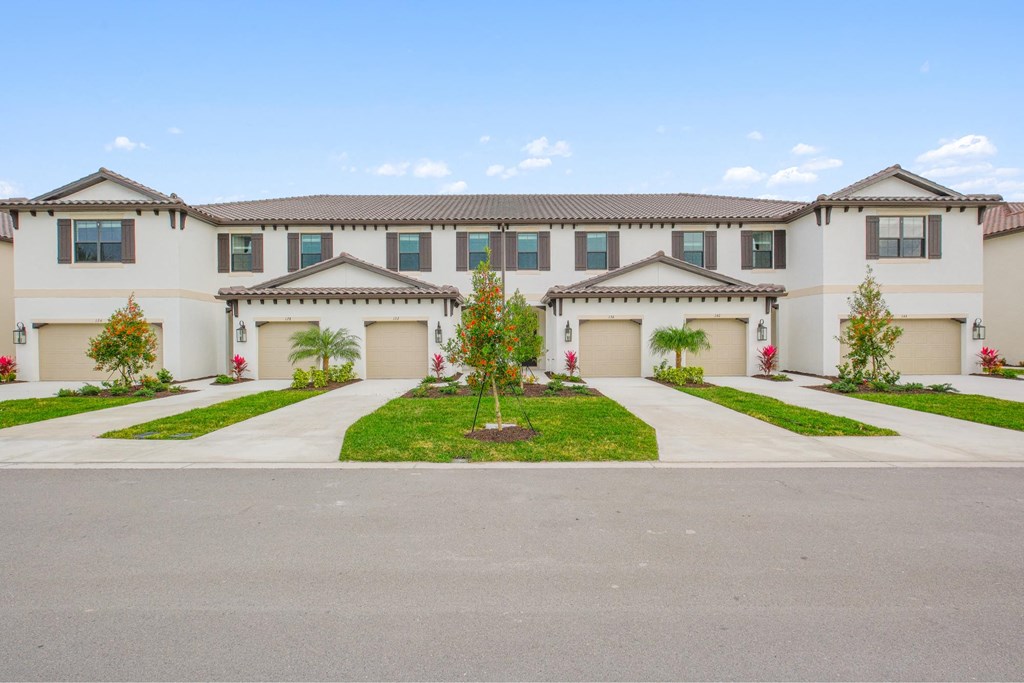 a large white house with two garage doors and a driveway at Fiore Townhomes, Florida