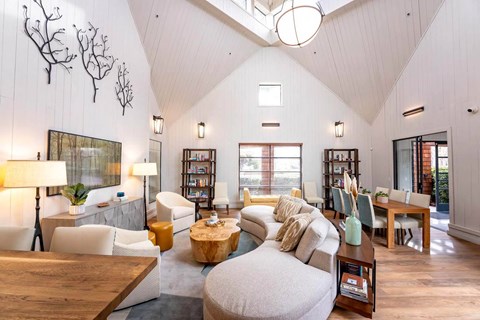 A living room with a white couch and a wooden coffee table.