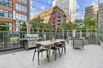 a patio with a table and chairs and a grill