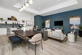a living room with blue walls and a dining room with a table and chairs