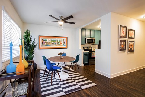 A living room with a ceiling fan and a painting on the wall.
